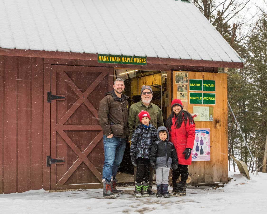 A family poses with the owner of a maple syrup farm near Lake Placid New York