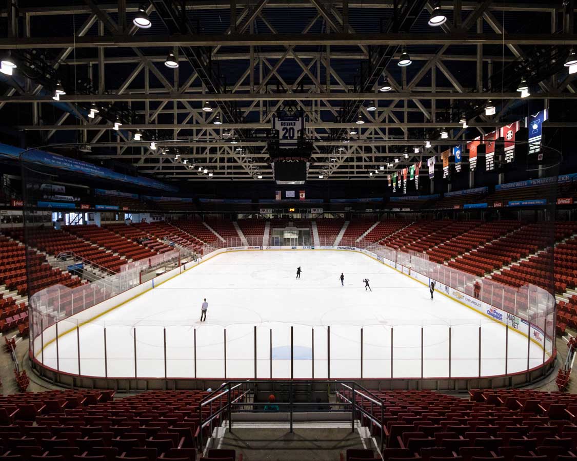 A small crowd skating at an Olympic skating rink in Lake Placid New York