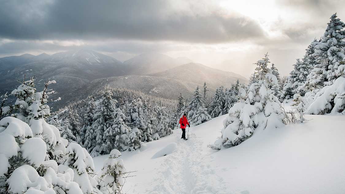 Snowshoer high in the Adirondack Mountains near Lake Placid in winter