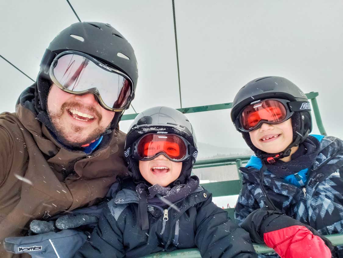 Father and two kids on a ski lift in the Finger Lakes of New York State