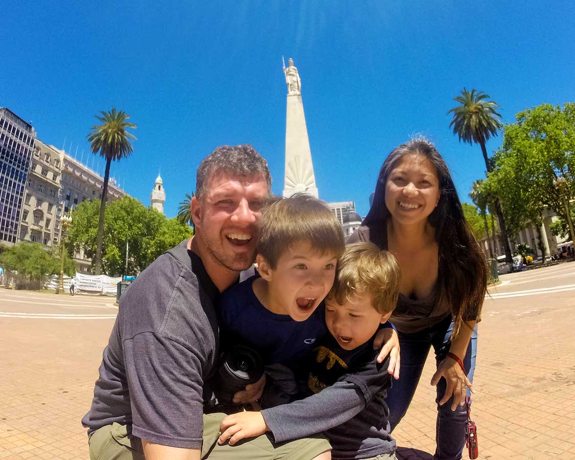 A young family making funny faces at the camera in a plaza in central Buenos Aires