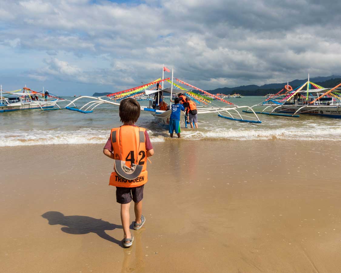 Boy boarding a paraw at the Puerto Princesa Subteranean River