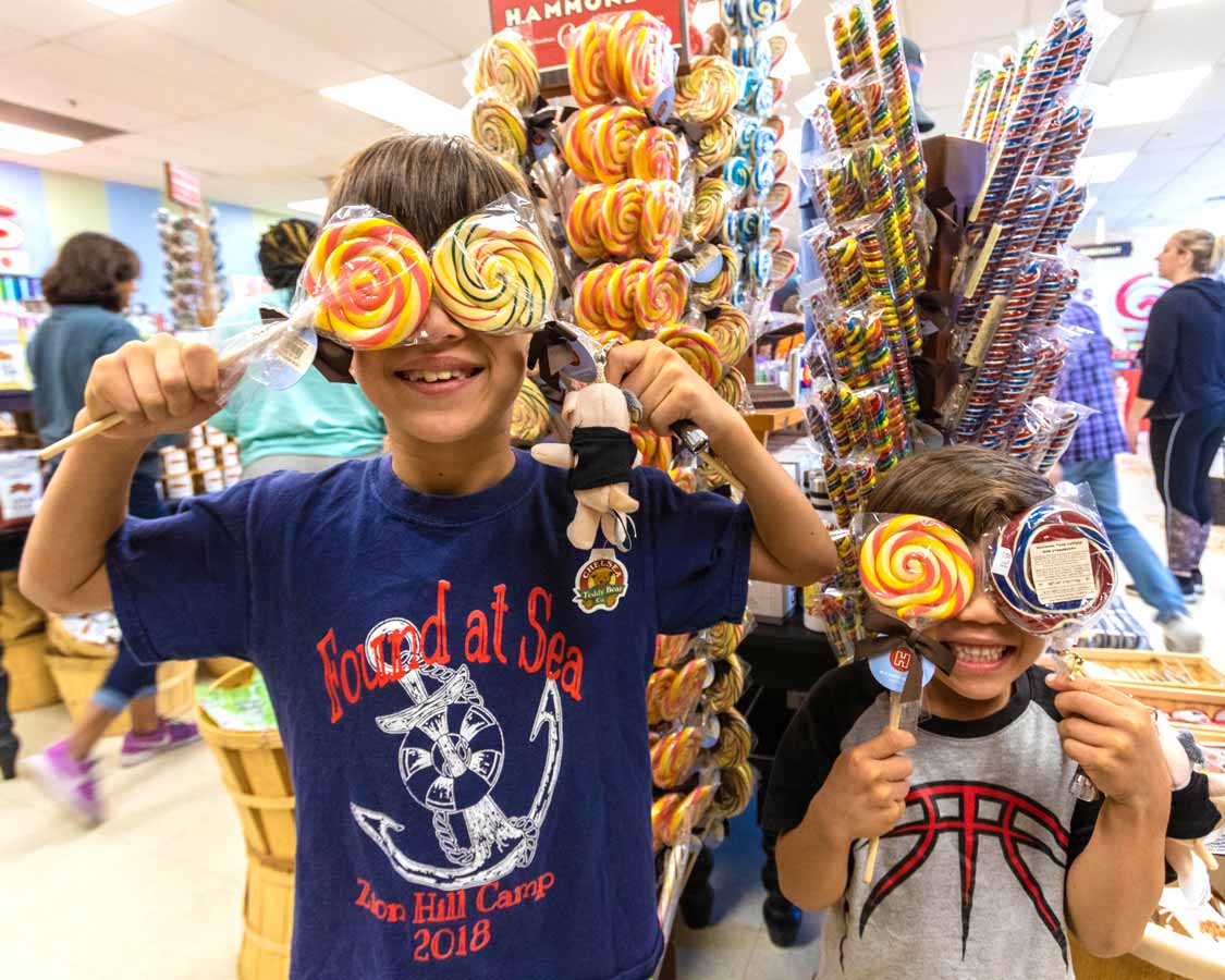 Children holding lollipops over their eyes at Hammond's Candy Factory