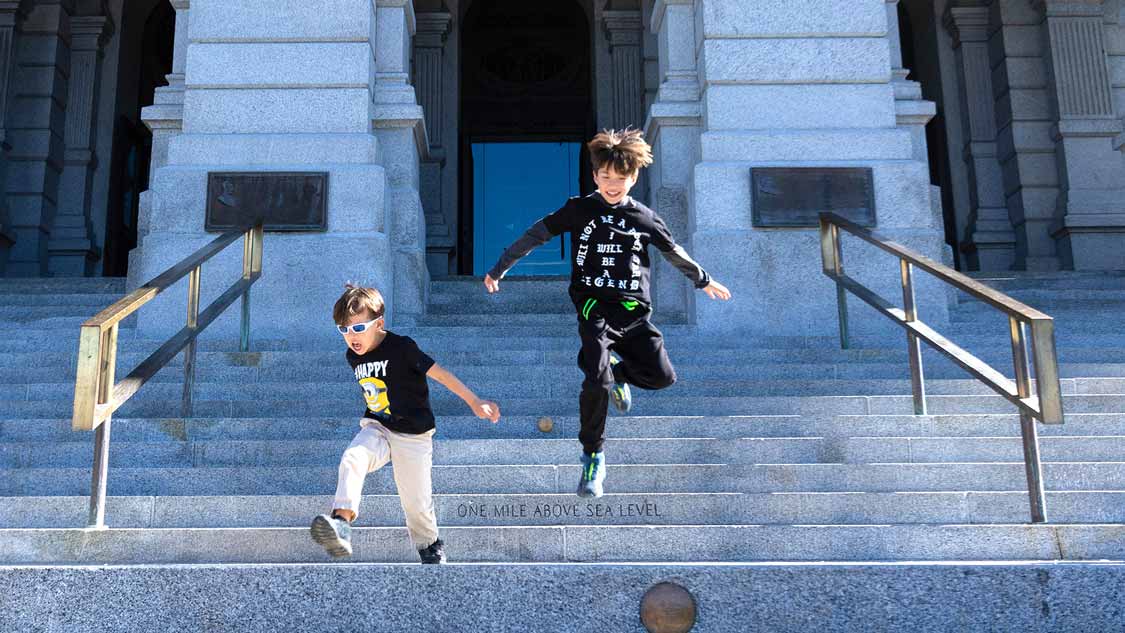 Two boys jumping from the mile-high step searching for things to do in Denver with kids