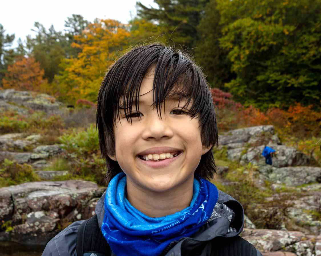 Boy hiking in the rain at French River Provincial Park