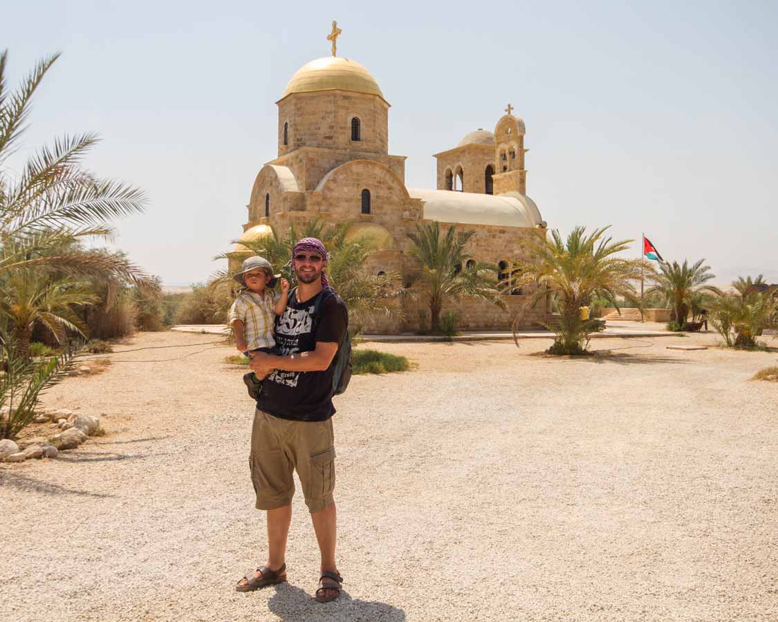 A boy and his son stand by a church at Bethany Beyond the Jordan