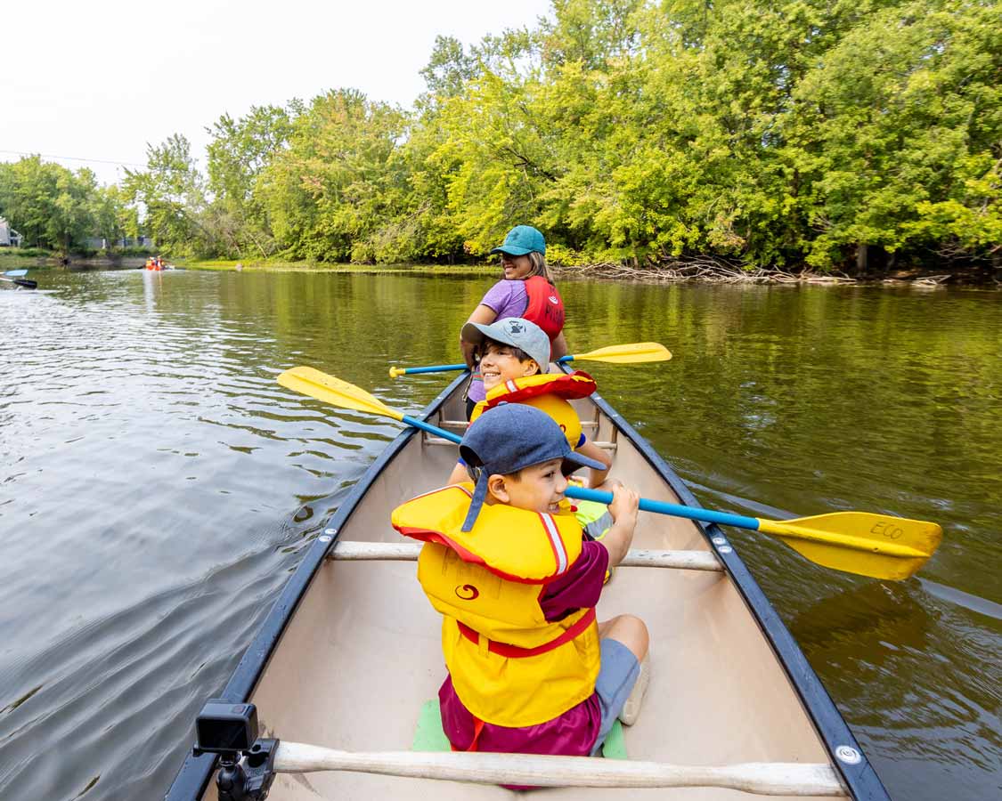 A family paddles a canoe in Parc de la Riviere Mille Isles in Laval, Quebec