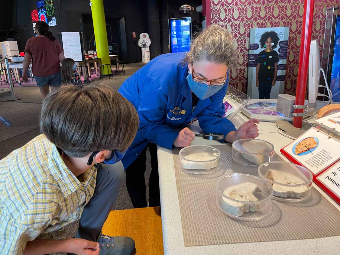 A Science North bluecoat teaches a child about biology