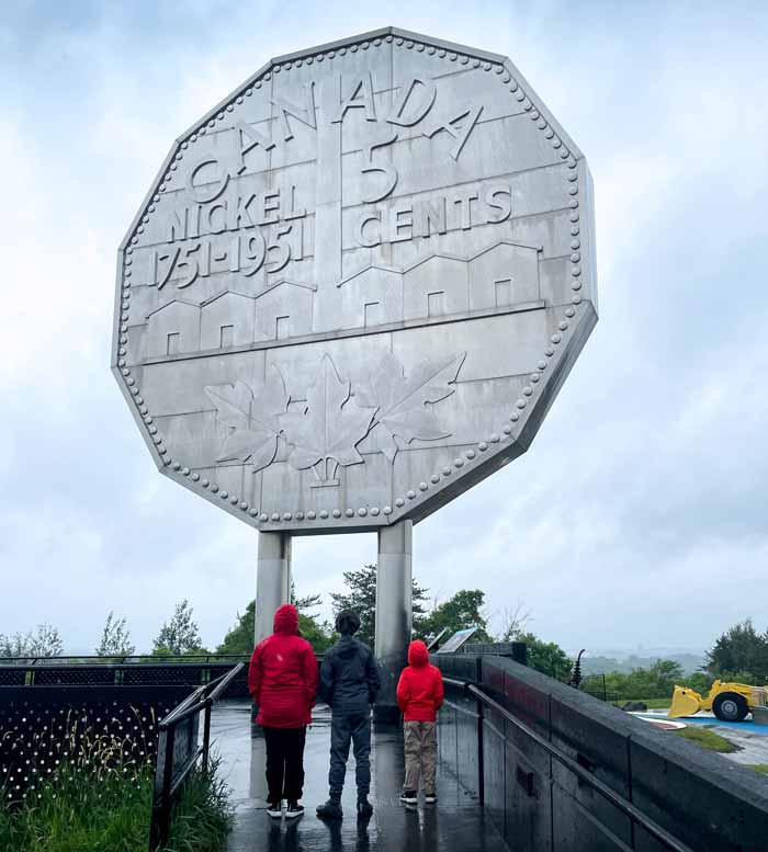 A family gazes up at the Big Nickel in Sudbury at Dynamic Earth