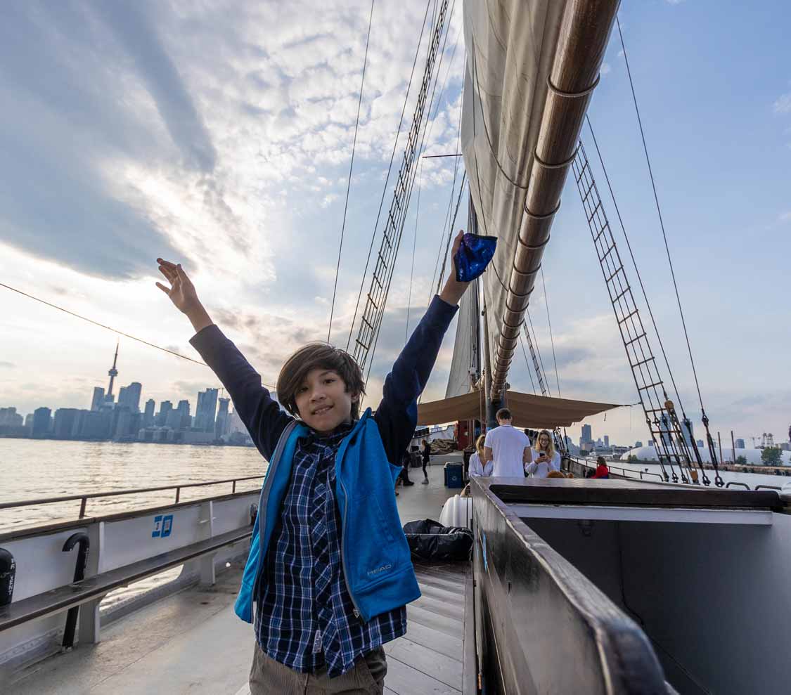 A boy raises his arms on the Tall Ship Kajama in Toronto for families