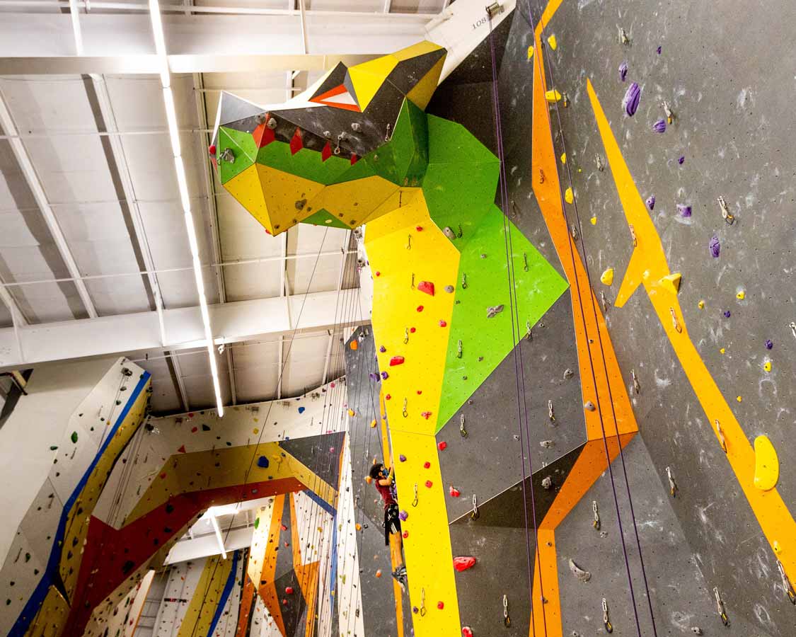 A boy climbs the Dragon climbing wall at Hub Climbing Mississauga