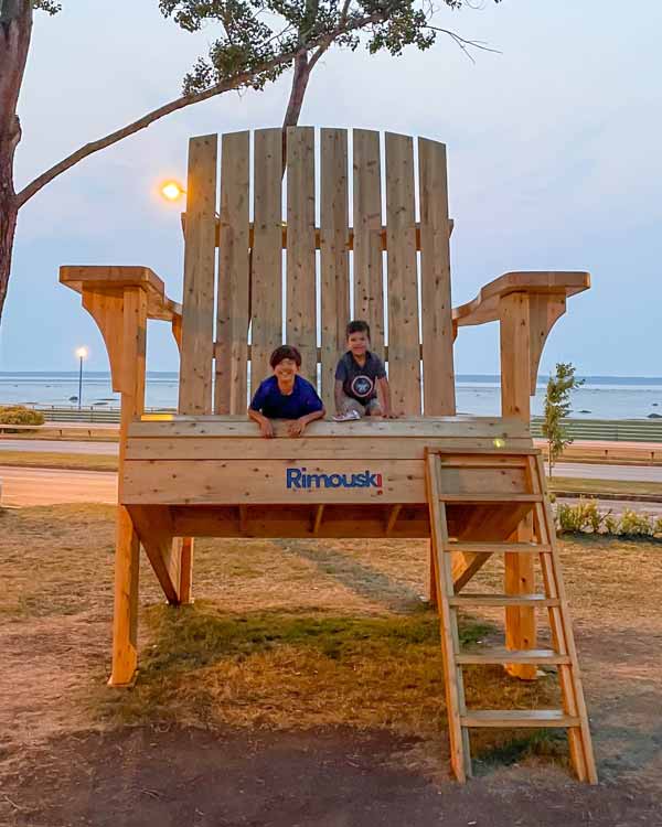 Boys play on a giant chair in Rimouski Quebec