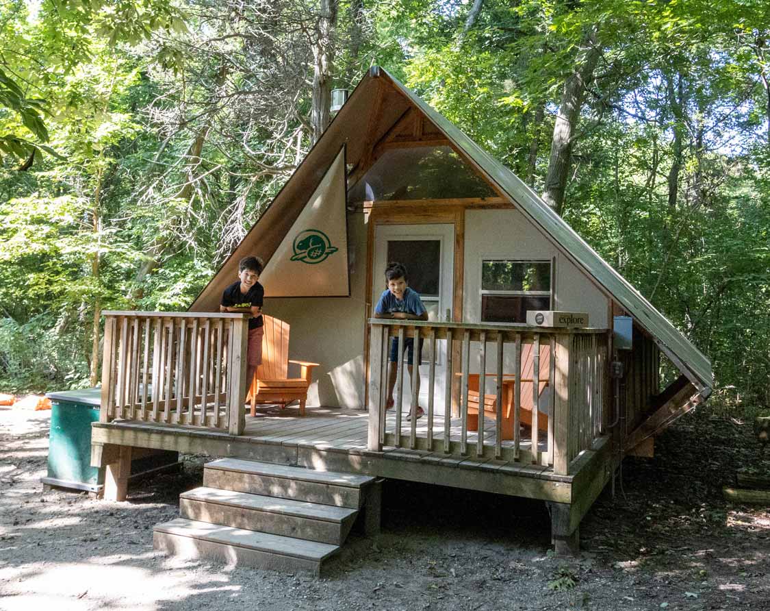 Boys standing on the deck of a glamping oTENTik at Point Pelee National Par