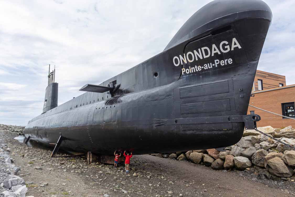 Two boys holding up the Onandaga Submarine in Rimouski, Quebec