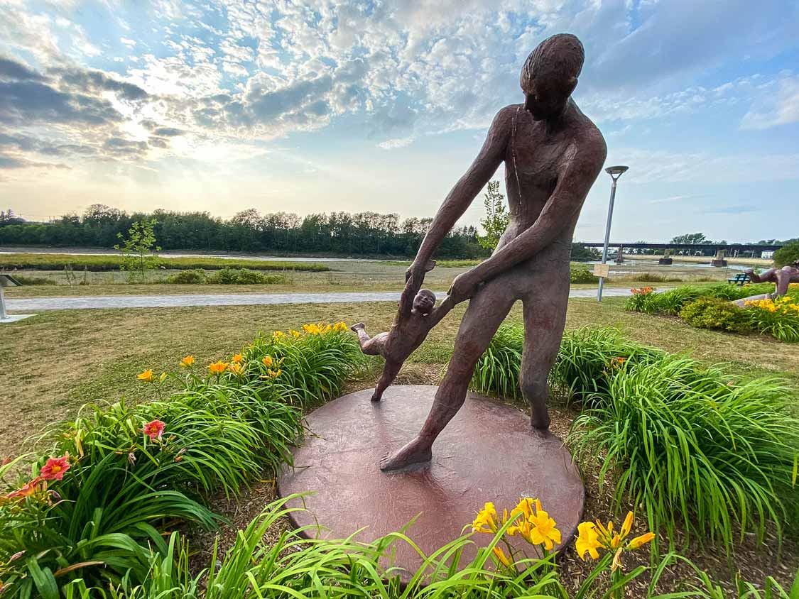 A sculpture of a man swinging his child in Rimouski Quebec
