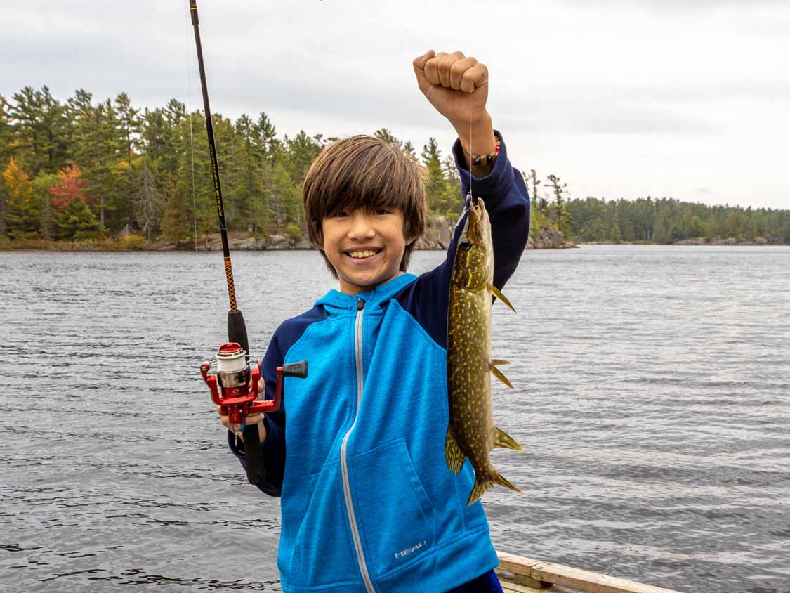 Boy holding a northern Pike while fishing at Grundy Lake Provincial Park
