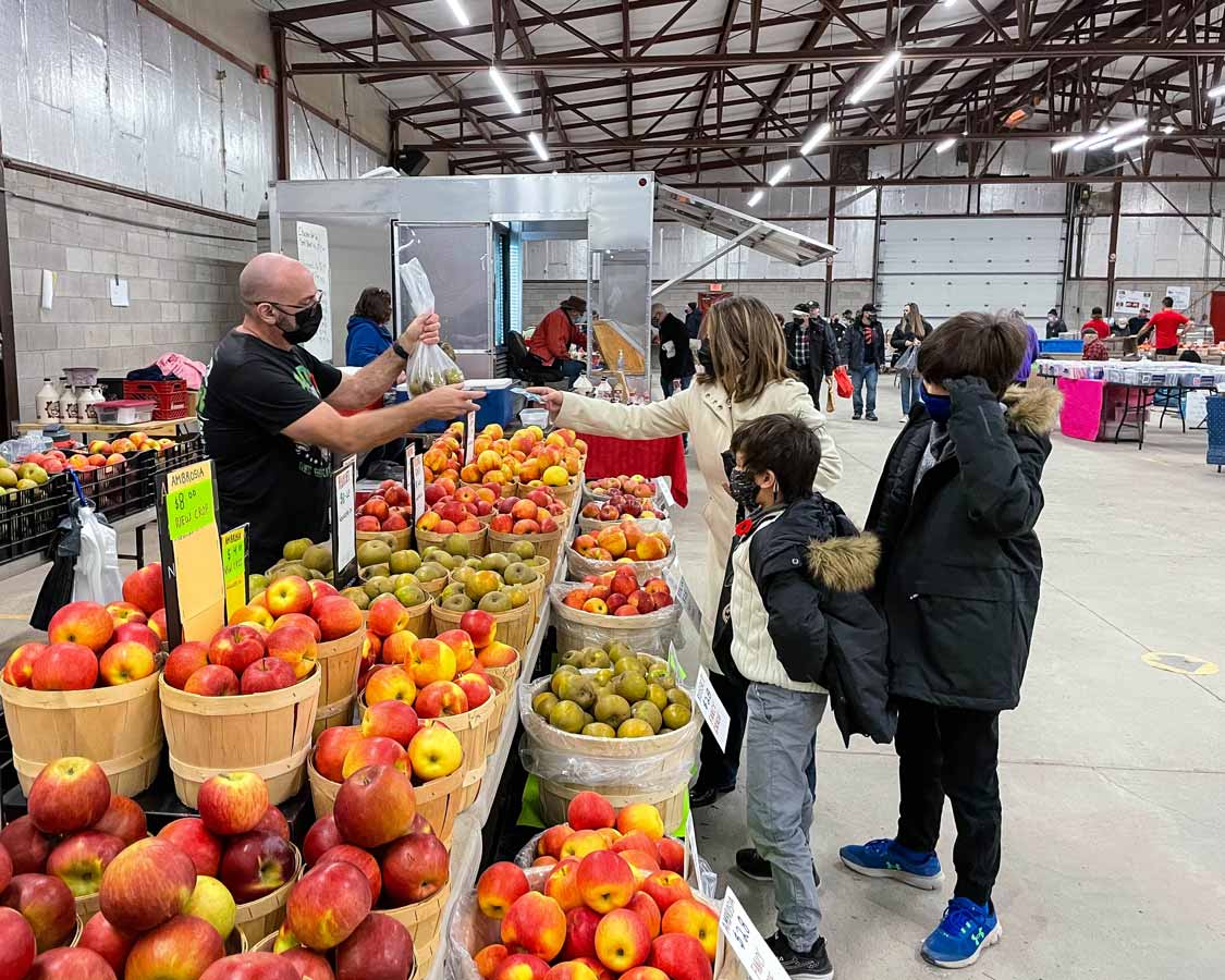 A mother buying fruit from the Peterborough Farmer's Market