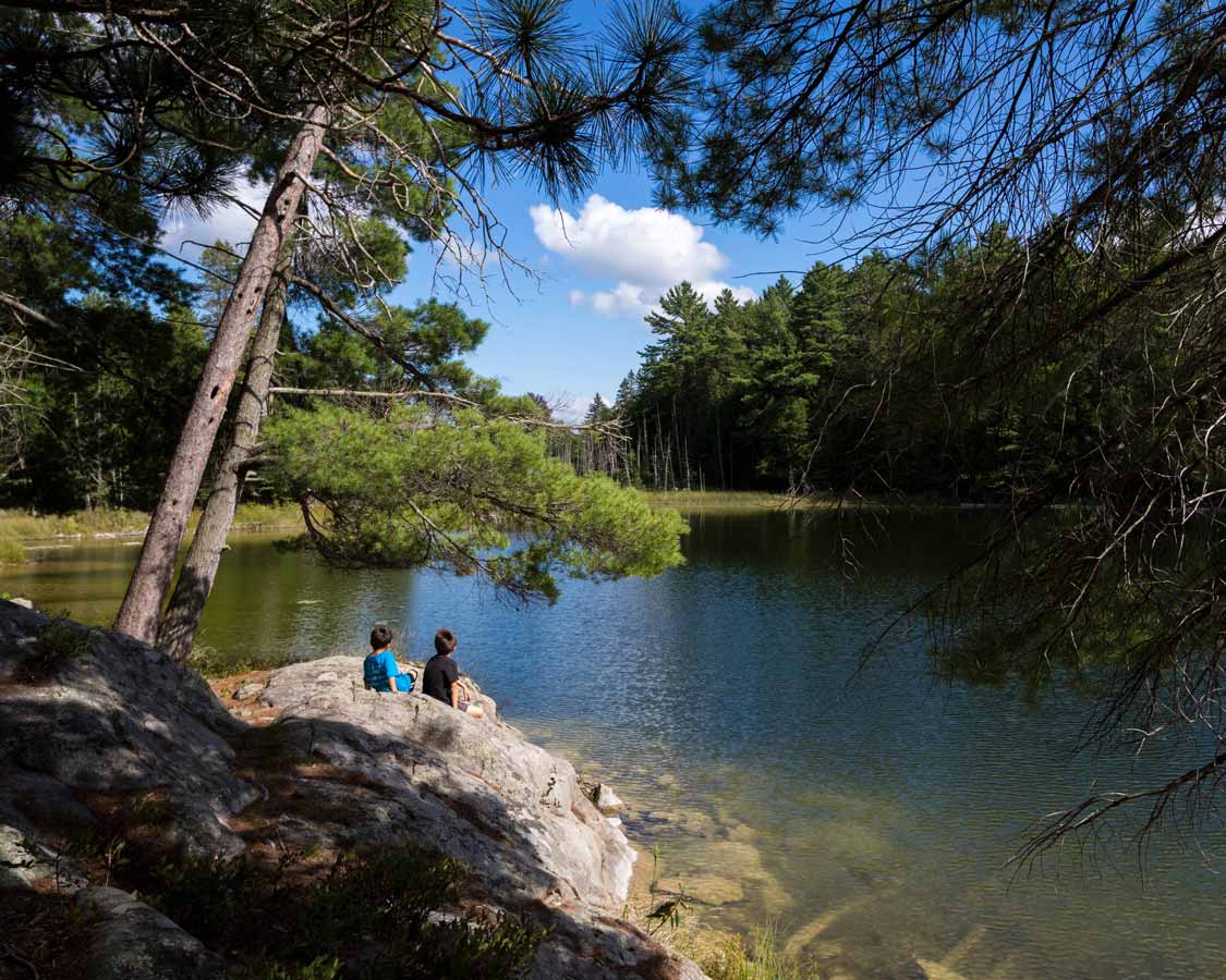 Two boys relaxing along the Marsh Hiking Trail in Petroglyphs Provincial Park