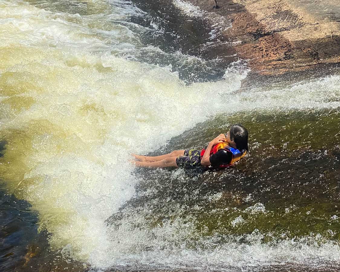 C Wagar slides down High Falls in Algonquin Park