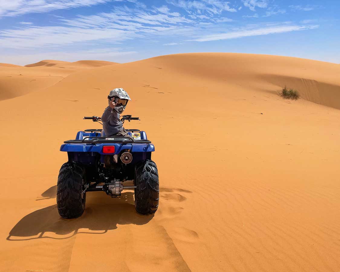 Young boy quad-biking in the Sahara desert of Morocco