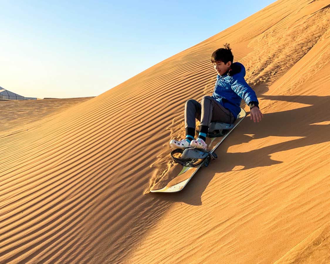 kids sandboarding in the Moroccan desert