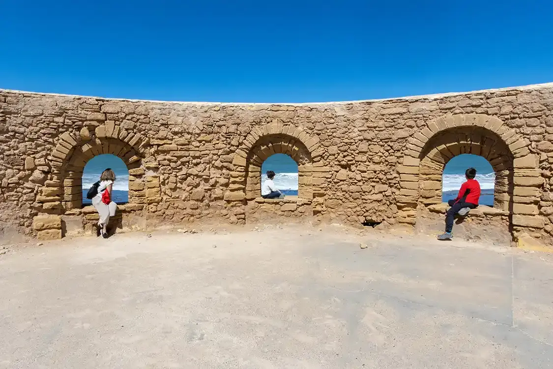 A woman and two boys framed in windows at the battlements in Rabat Morocco