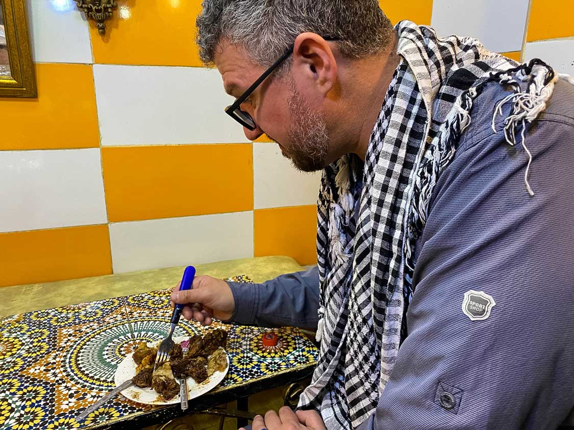 Man eating bull testicles on a Fes food tour