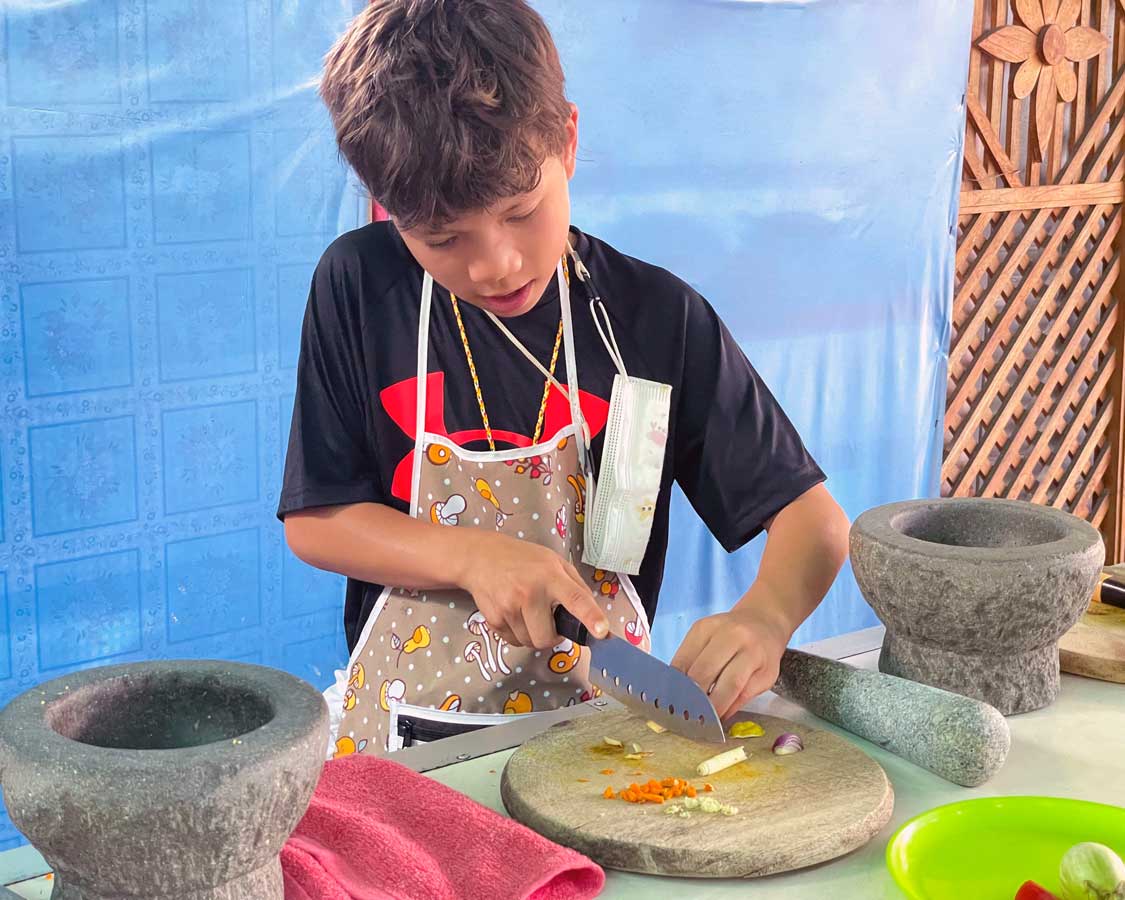 Young boy cooking at a Thai cooking class