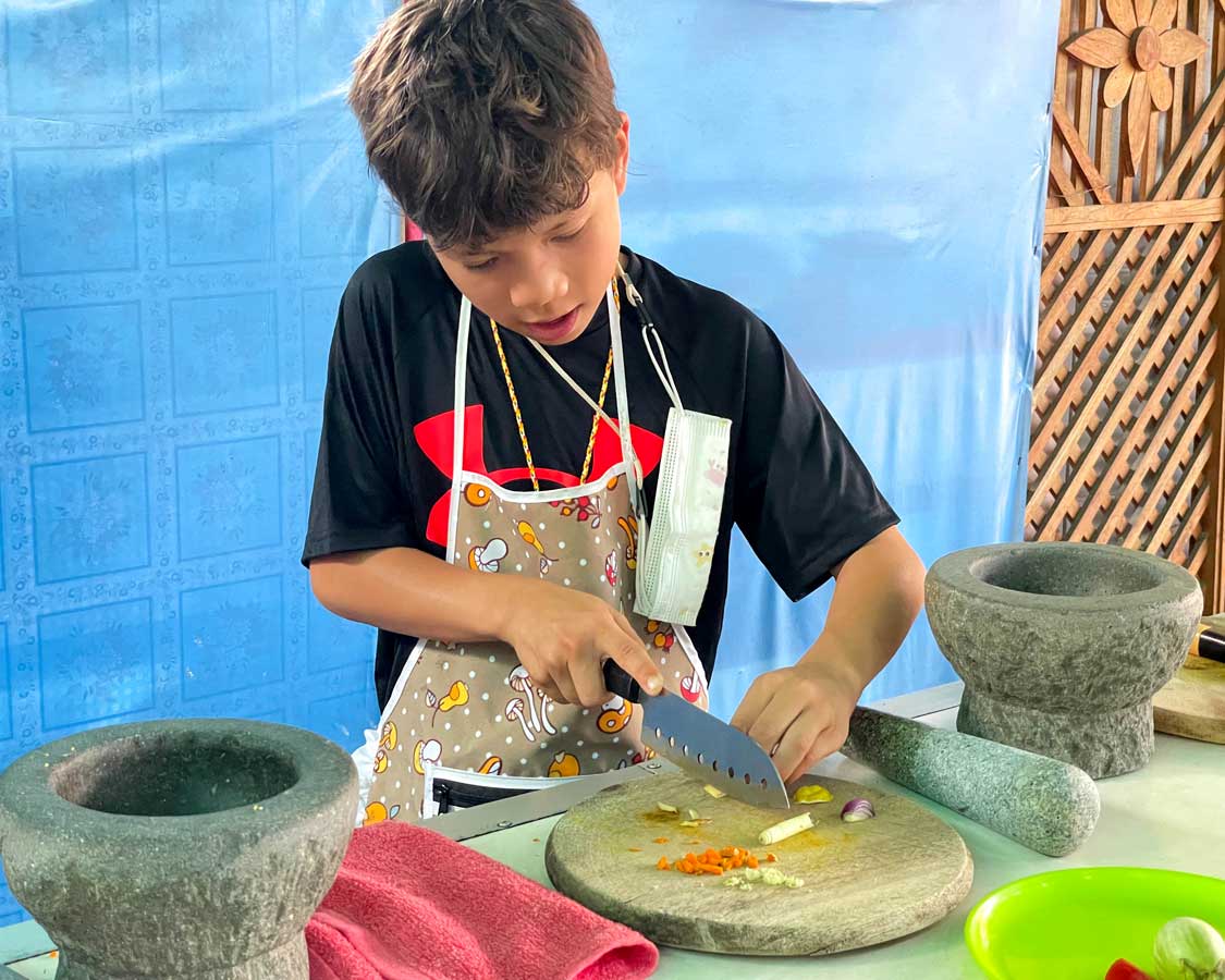 Boy taking a Thai cooking class in Chiang Mai, Thailand
