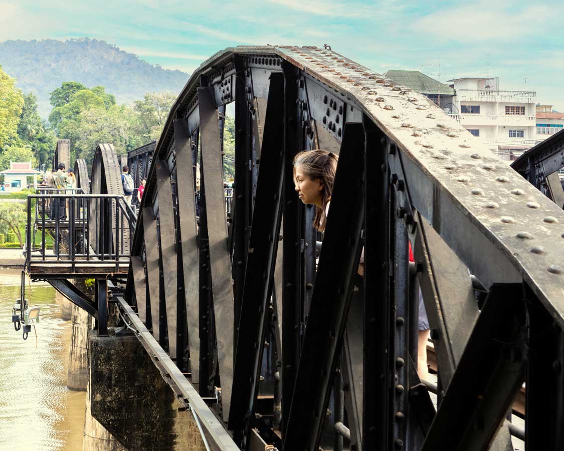 Woman looks out from the Kwai River Bridge on the Death Railroad