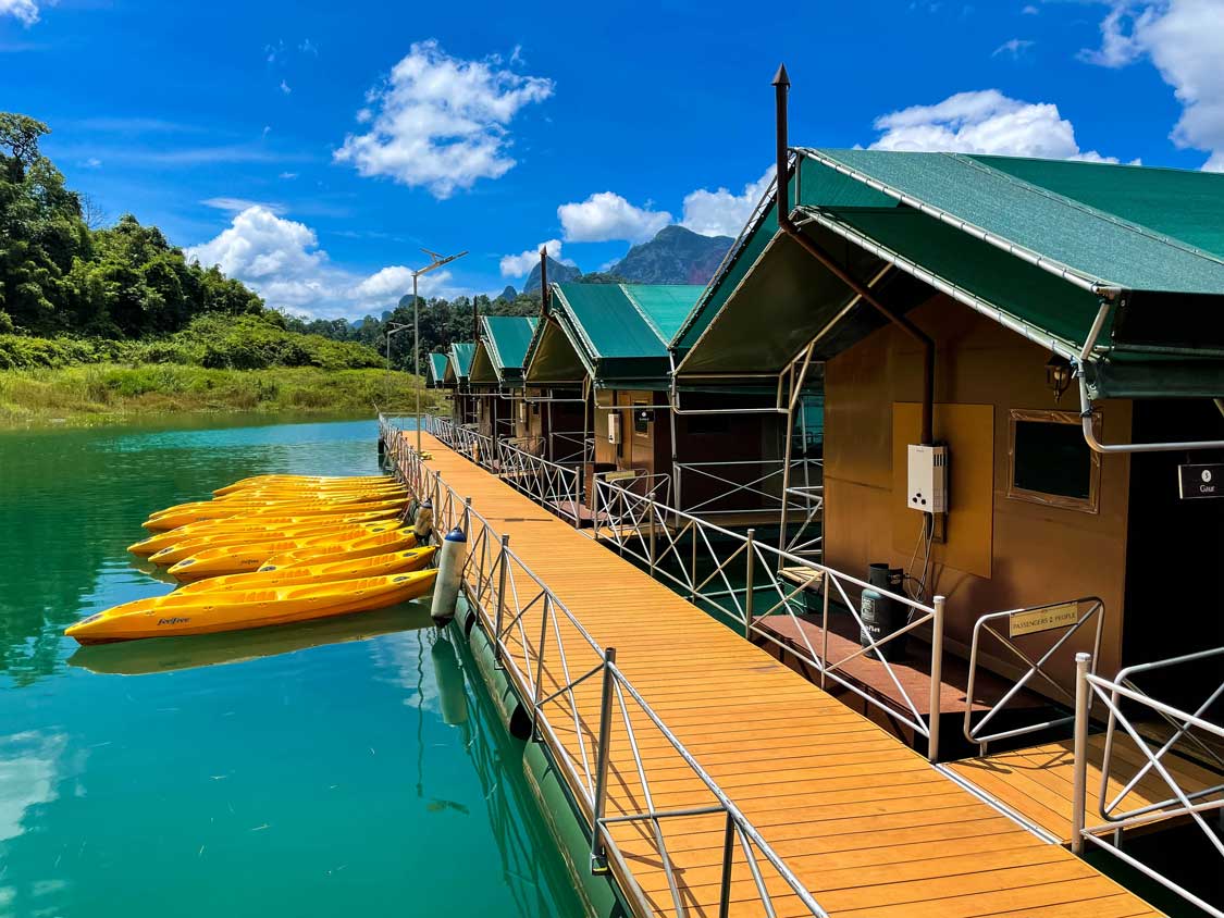 Floating lodges in Khao Sok National Park with kayaks in front of them at Elephant Hills Rainforest Floating Lodge