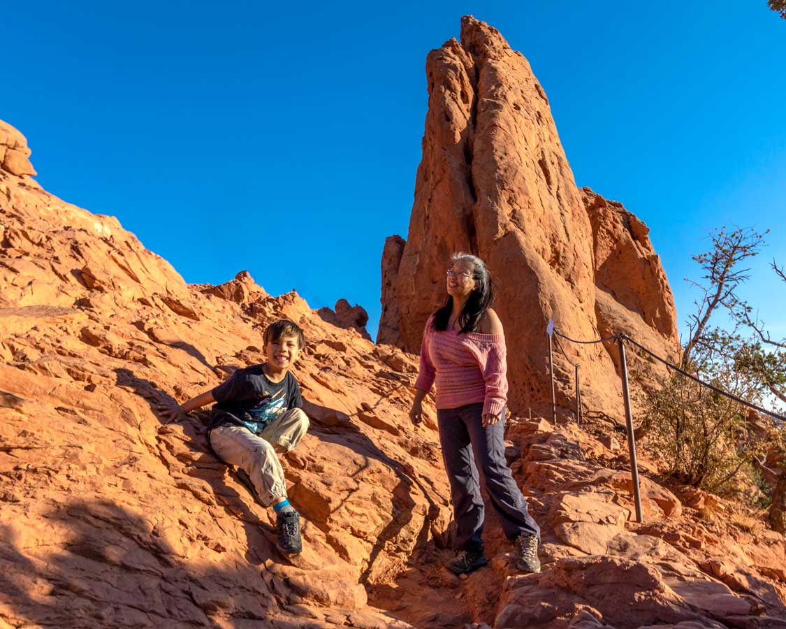 Woman and son hiking among towering red rocks in Garden of the Gods, Colorado Springs