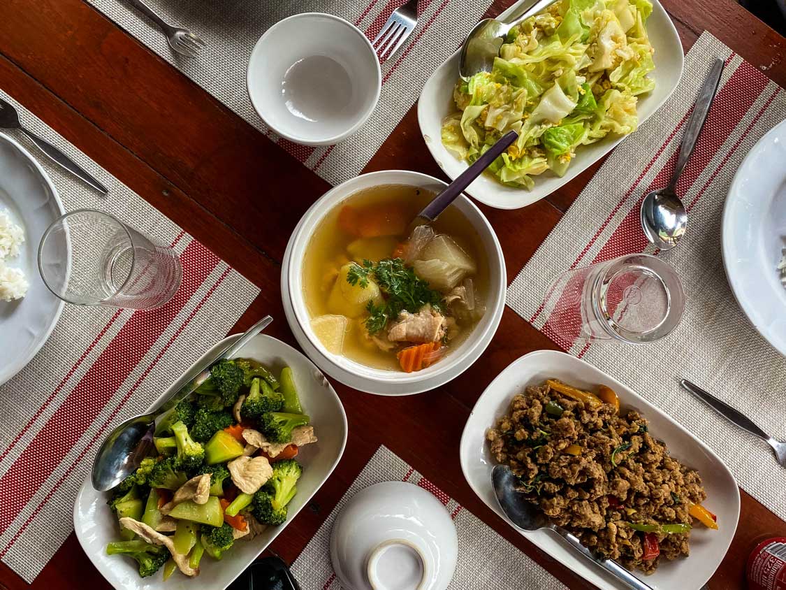 A table of soups, curries, and ground meat is food at River Kwai Jungle Rafts floating hotel
