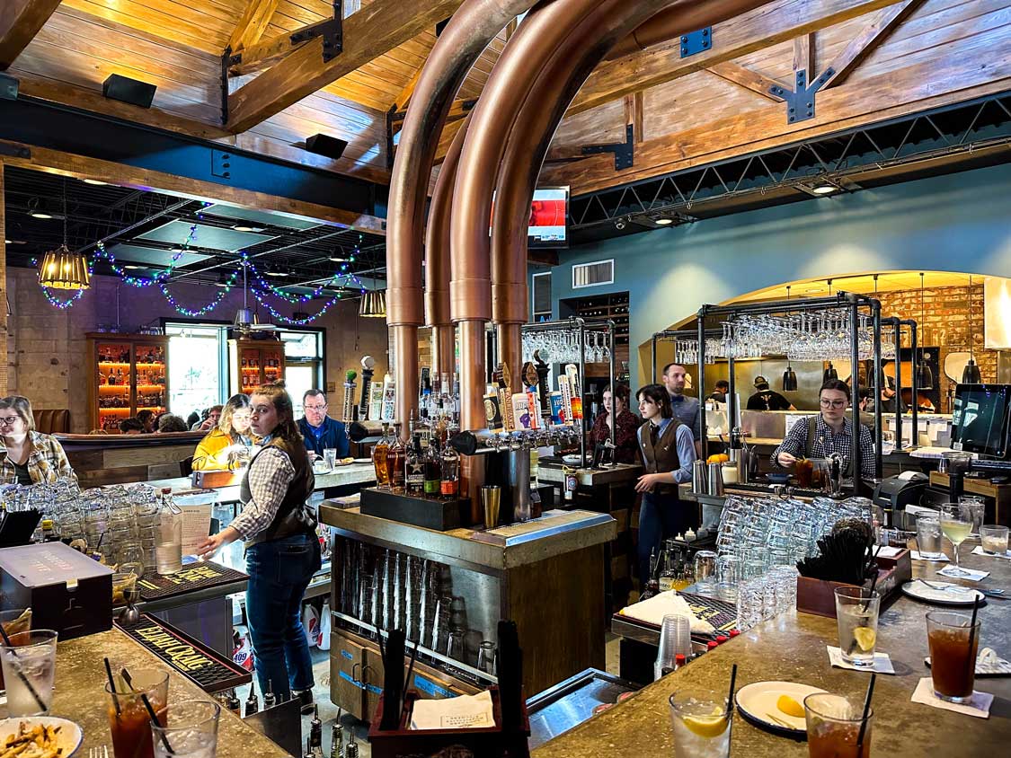 Massive copper pipes rise from the center bar at Social Table restaurant in Lafayette