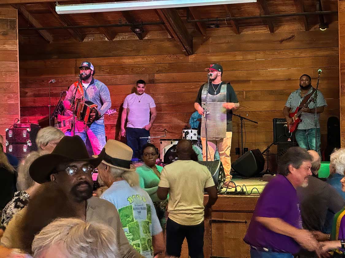 A band plays Zydeco music on guitars, steel pans, and a trumpet at a Lafayette dance hall in Louisiana