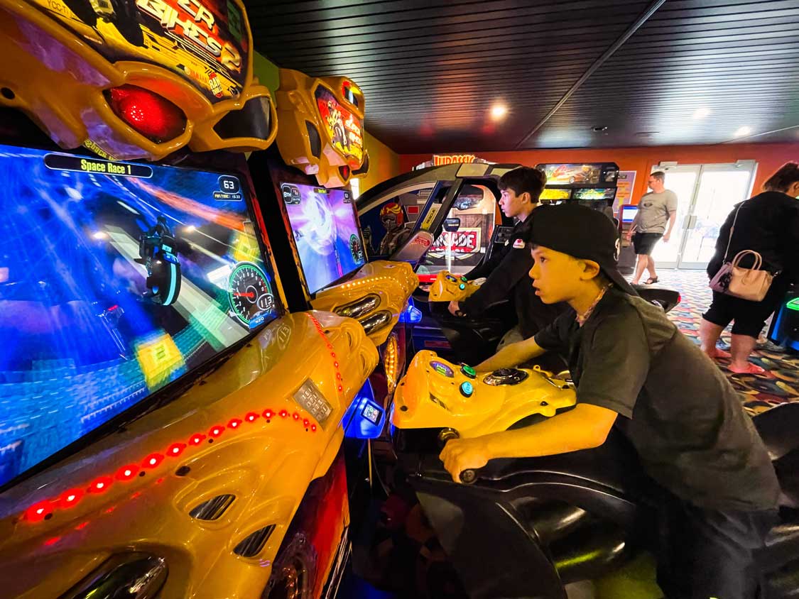 Two boys play a racing game at Magnetic Hill TekZone arcade