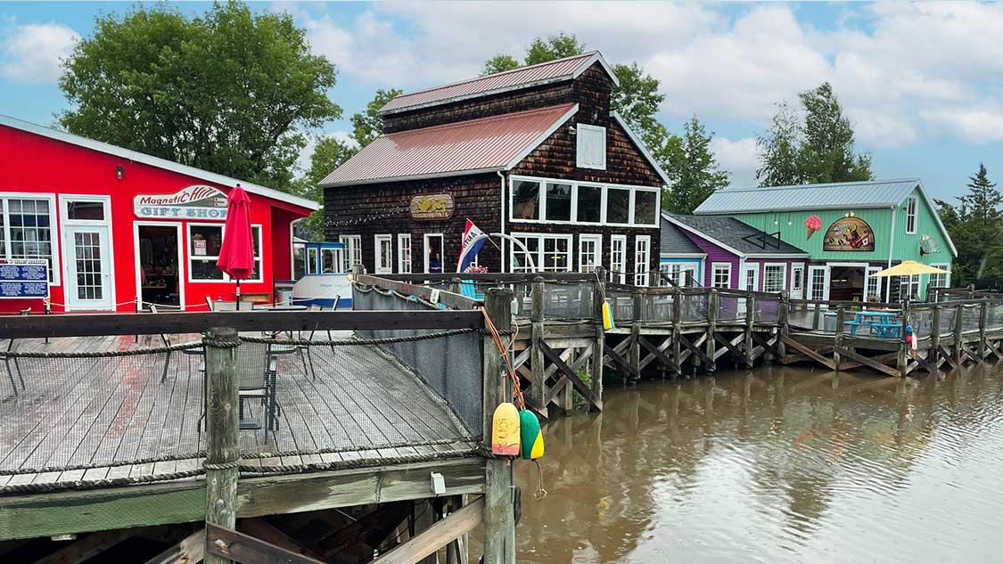 Colorful buildings sit on a pier at the Magnetic Hill Moncton Wharf Village