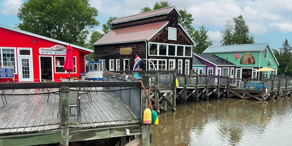 Colorful buildings sit on a pier at the Magnetic Hill Moncton Wharf Village