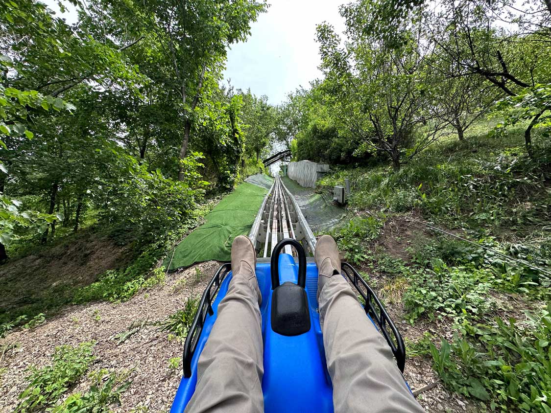 First person view of a man riding a mountain coaster at Kok-Tobe amusment park in Almaty, Kazakhstan