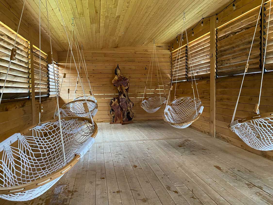 Hammock seats hang from the roof of a wooden room at USVA Spa Nordic in Moncton