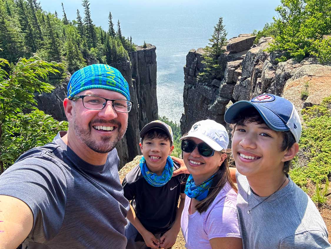 A smiling family takes a picture at the Gorge Viewpoint in Sleeping Giant Provincial Park