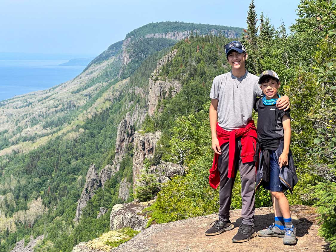 Kids smiling at a viewpoint along a mountain ridge at Sleeping Giant Provincial Park