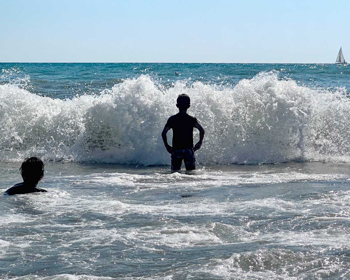 You boy braving large waves at Patara Beach on Turkiyes Turquoise Coast