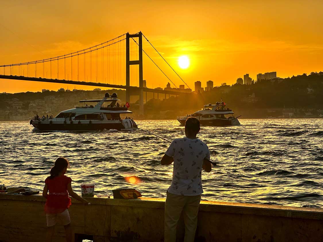 Fishermen watch boats cruise the Bosporos Strait in Istanbul