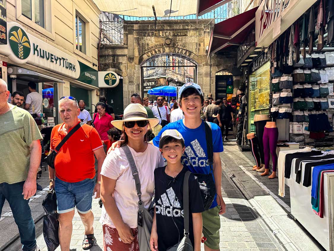 A family smiling in front of the Grand Bazaar in Istanbul, Turkiye
