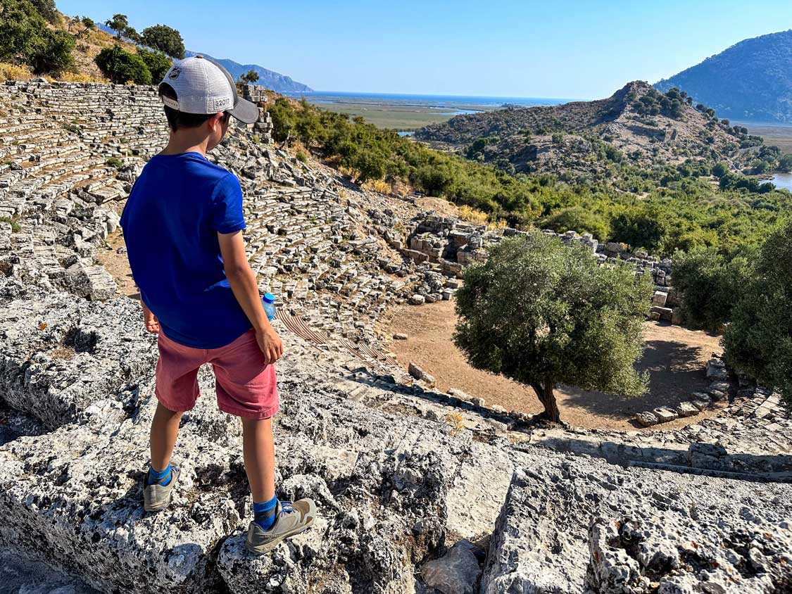 A boy looks out over the Grand Theater at the Kaunos ruins in Dalyan