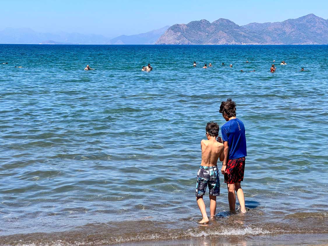 Two boys look out into the Mediterranean Sea from Iztuzu Beach