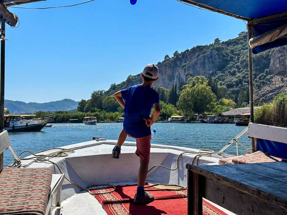 A boy giving an epic pose while cruising down the Dalyan River