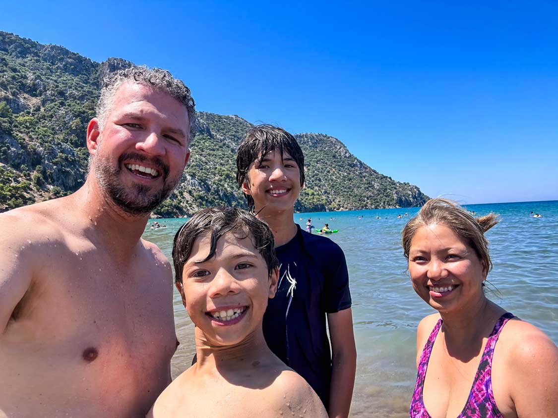 A family smiles for a selfie at Izutzu Beach near Dalyan