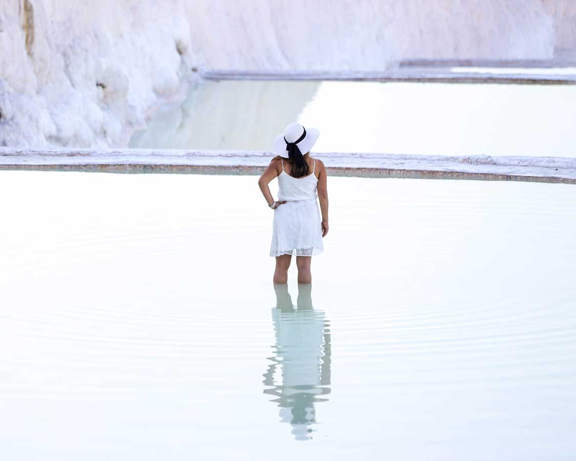 A woman wading in the geothermal pools of the Cotton Castle in Pamukkale, Turkiye